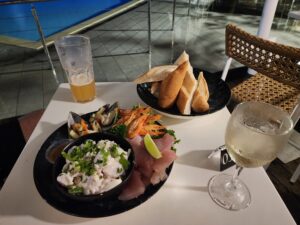 Bar table with a seafood platter, baguette and 2 drinks